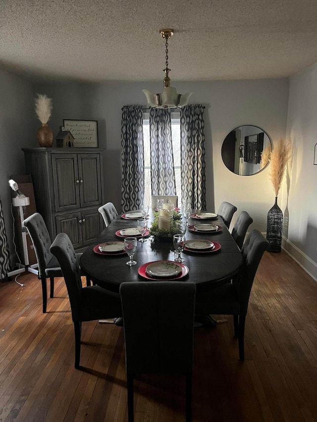 dining area with a textured ceiling, baseboards, a chandelier, and dark wood-style flooring