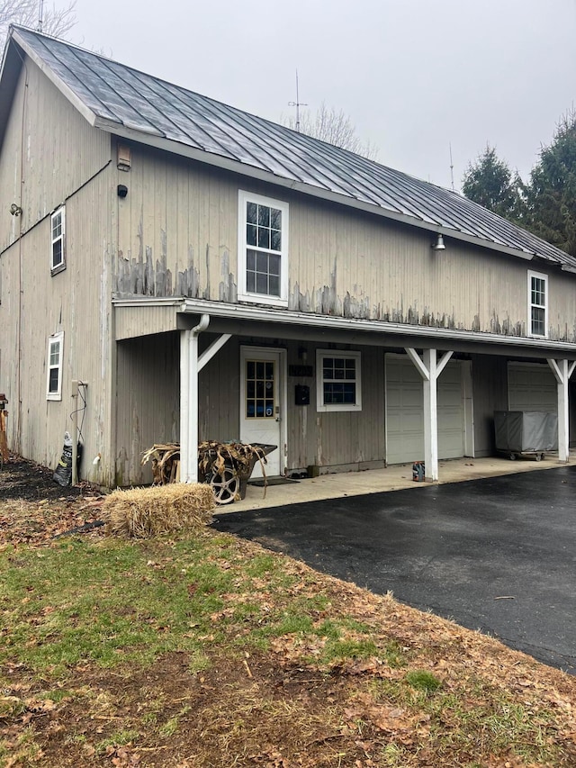 view of front facade featuring a garage, a standing seam roof, and metal roof