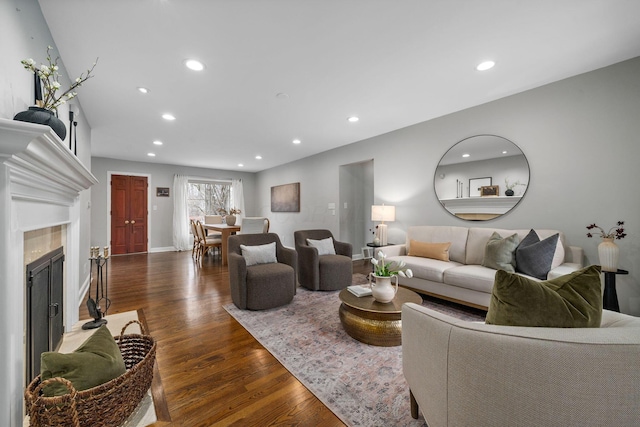 living area featuring dark wood-type flooring, recessed lighting, a fireplace, and baseboards