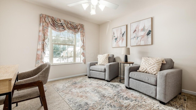 living area with light carpet, ceiling fan, and baseboards