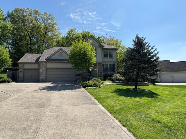 936 Howell Dr, Newark, OH 43055 - view of front of home with a front yard, concrete driveway, a garage, and stone siding