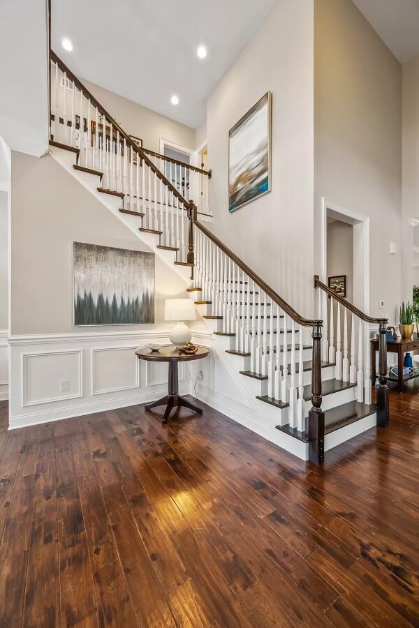 stairs with hardwood / wood-style flooring and a high ceiling