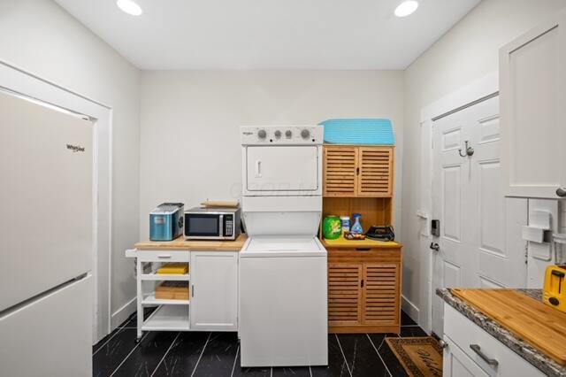 clothes washing area featuring stacked washer / drying machine