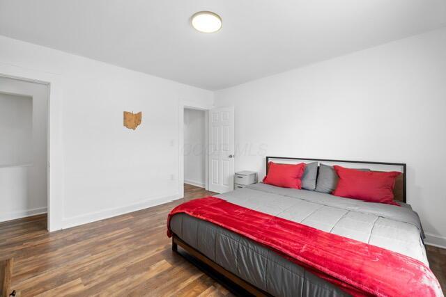 bedroom with dark wood-type flooring