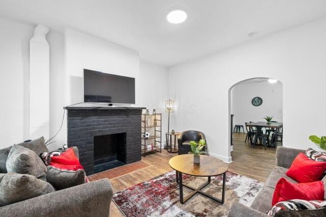 living room with hardwood / wood-style flooring and a brick fireplace