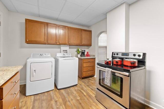 laundry room with separate washer and dryer and light hardwood / wood-style flooring