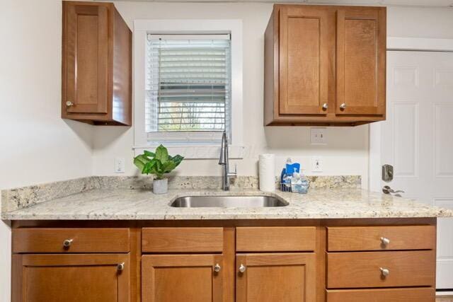 kitchen featuring sink and light stone counters