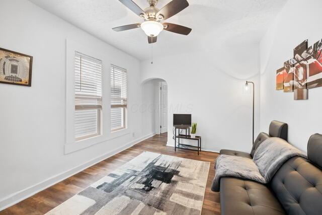 living room featuring wood-type flooring and ceiling fan