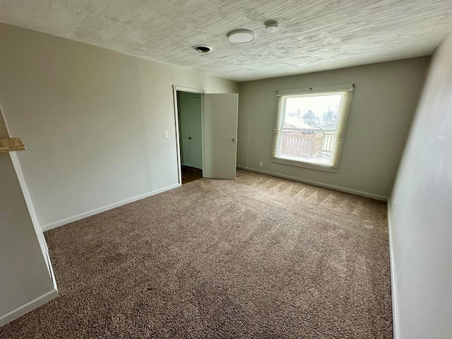 carpeted empty room with a textured ceiling