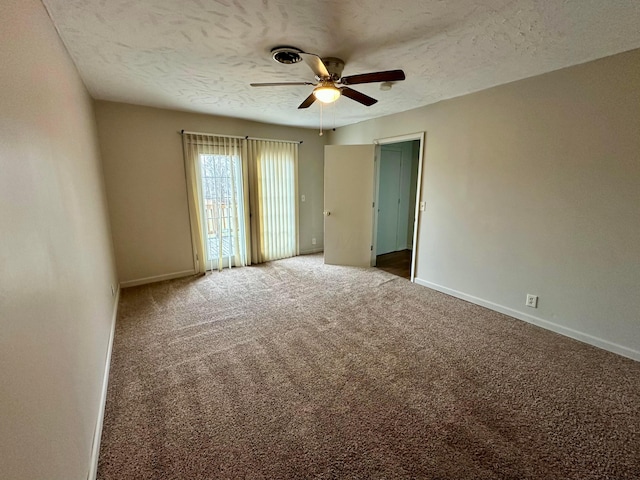 carpeted empty room featuring ceiling fan and a textured ceiling