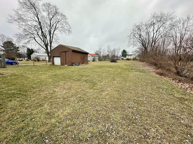 view of yard featuring a garage and an outdoor structure