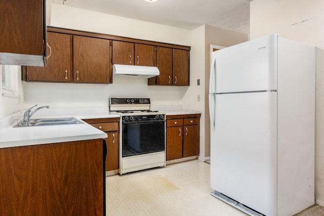 kitchen with white refrigerator, gas range, and sink