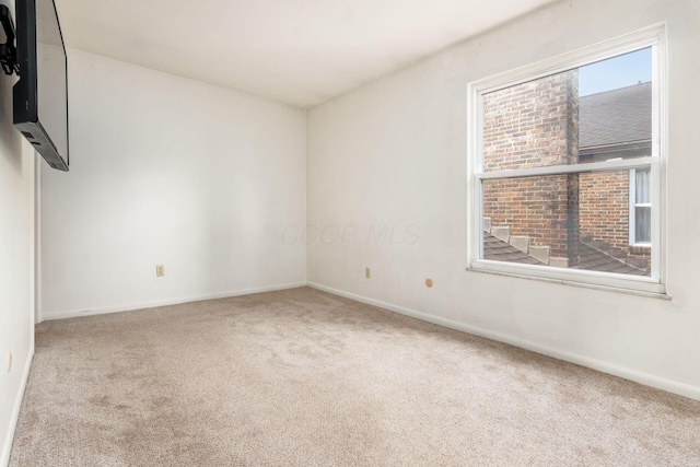 unfurnished room featuring light colored carpet