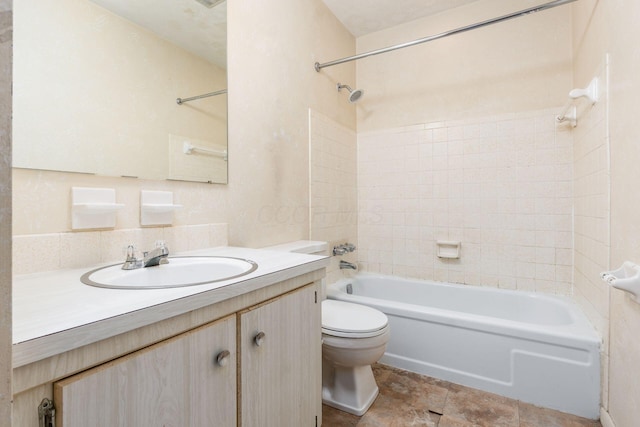 full bathroom with tiled shower / bath, vanity, and toilet