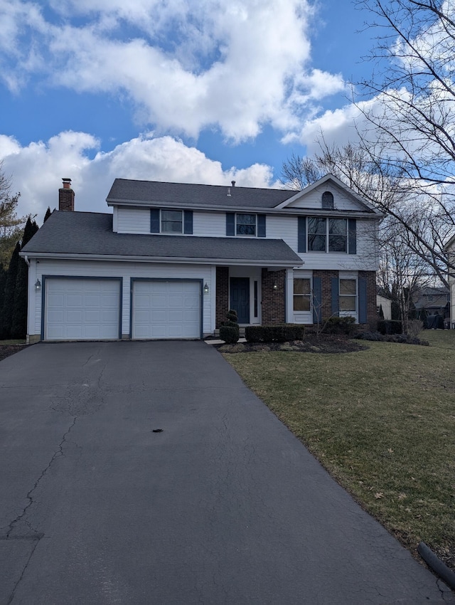 traditional home with a front lawn, an attached garage, driveway, and a chimney