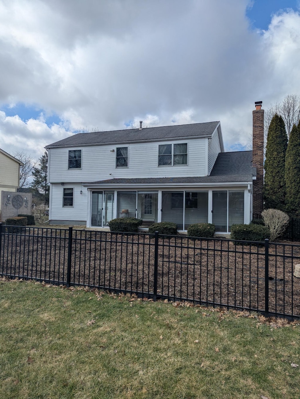 rear view of property with a fenced front yard and a chimney