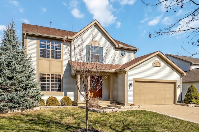 traditional-style home featuring a garage, driveway, a front lawn, and roof with shingles