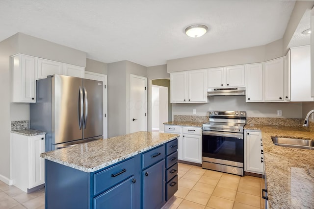 kitchen with stainless steel appliances, white cabinets, a sink, blue cabinets, and under cabinet range hood