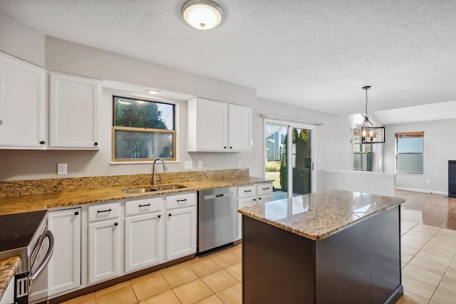 kitchen featuring a sink, a center island, white cabinets, appliances with stainless steel finishes, and light stone countertops