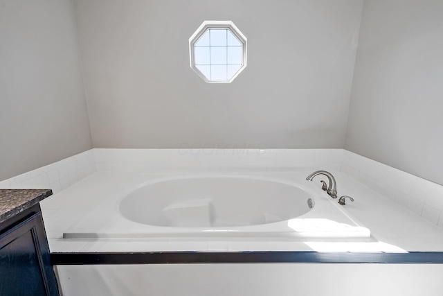 bathroom featuring a garden tub and vanity