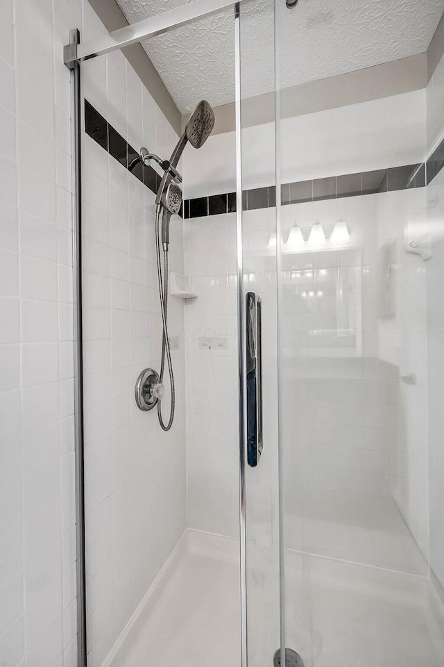 bathroom with a stall shower and a textured ceiling