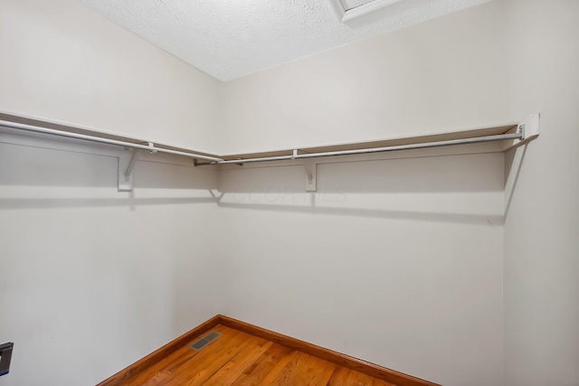 walk in closet featuring visible vents and wood finished floors