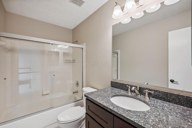 bathroom featuring shower / bath combination with glass door, visible vents, toilet, vanity, and a textured ceiling