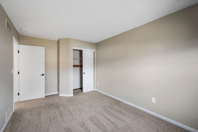 unfurnished bedroom with carpet floors, baseboards, visible vents, and a textured ceiling