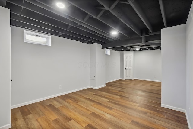 below grade area featuring baseboards and wood finished floors