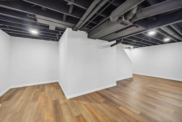 finished basement featuring wood finished floors and baseboards