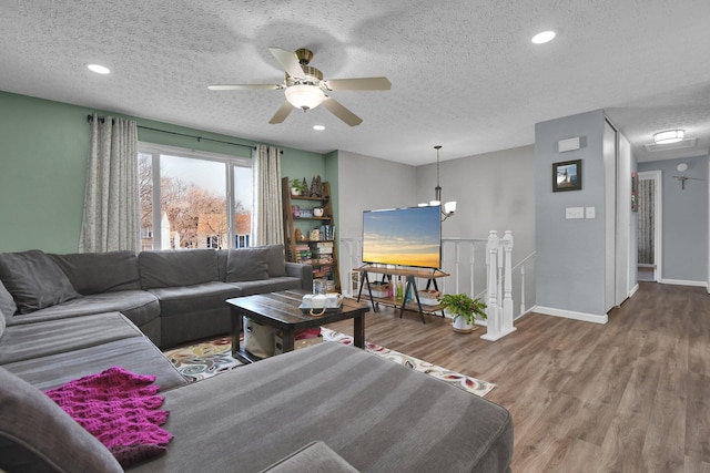 living room with ceiling fan, hardwood / wood-style floors, and a textured ceiling