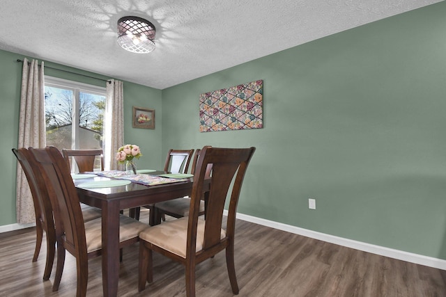 dining area with a textured ceiling and dark hardwood / wood-style flooring