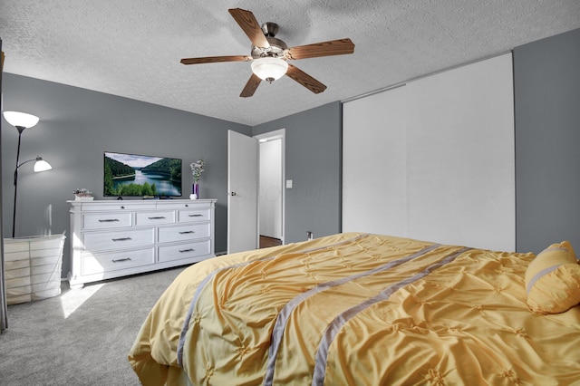 bedroom with ceiling fan, a textured ceiling, and carpet