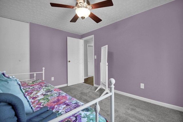 carpeted bedroom with ceiling fan and a textured ceiling