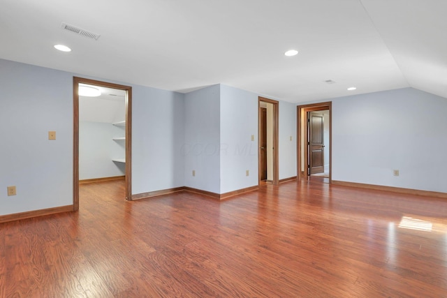 spare room featuring vaulted ceiling and hardwood / wood-style floors