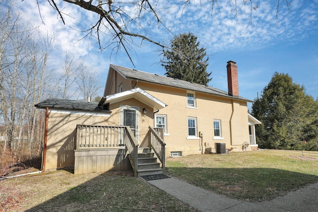 view of front facade featuring a front yard and central air condition unit