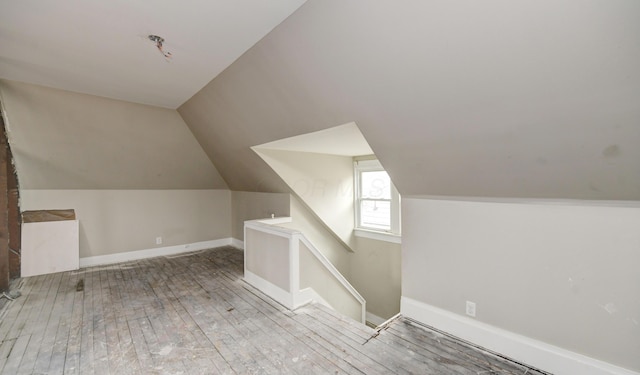 additional living space featuring lofted ceiling and light wood-type flooring