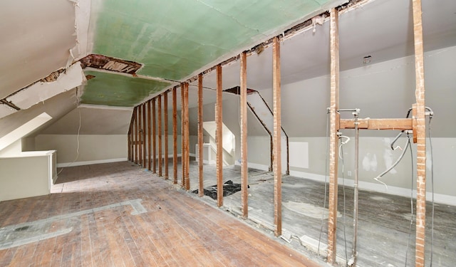 staircase with vaulted ceiling and wood-type flooring