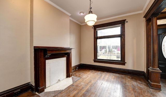 unfurnished living room with hardwood / wood-style floors, crown molding, decorative columns, and a tile fireplace