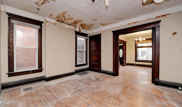 unfurnished room with light hardwood / wood-style flooring and a notable chandelier