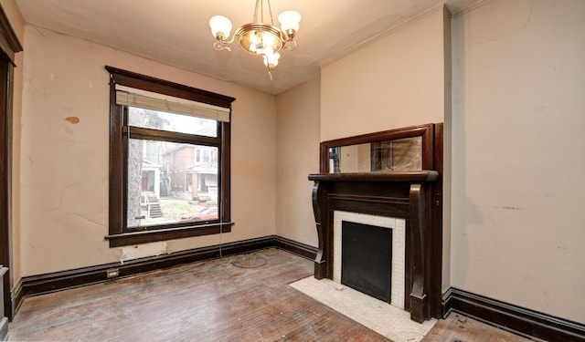 unfurnished living room with a tile fireplace, wood-type flooring, and an inviting chandelier