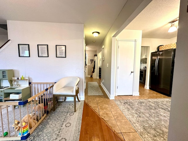 corridor featuring light hardwood / wood-style floors and a textured ceiling