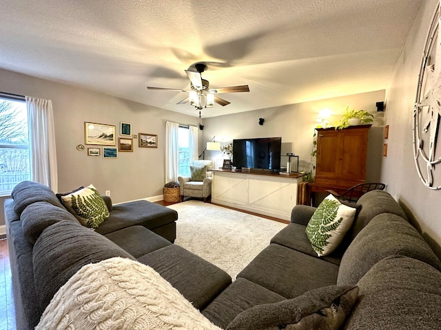 living room featuring a textured ceiling and ceiling fan