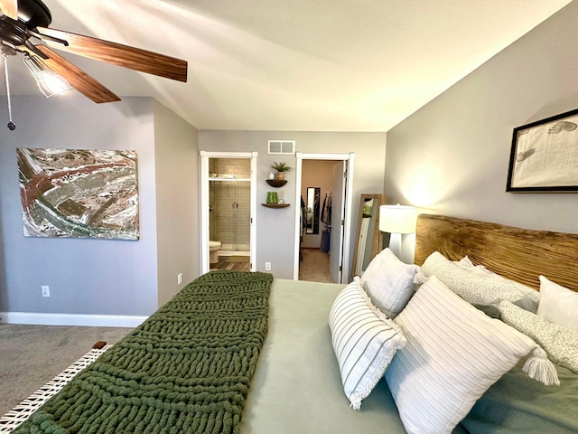 bedroom featuring ensuite bathroom, a spacious closet, vaulted ceiling, carpet floors, and ceiling fan