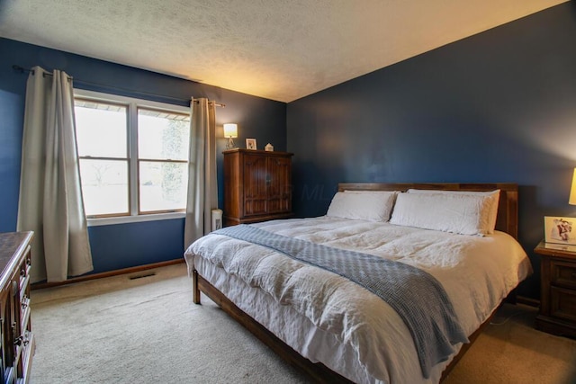 bedroom featuring light carpet and a textured ceiling