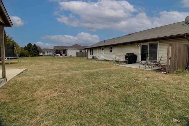 view of yard with a trampoline and a patio area