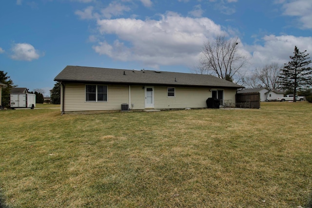 back of property with central AC and a yard