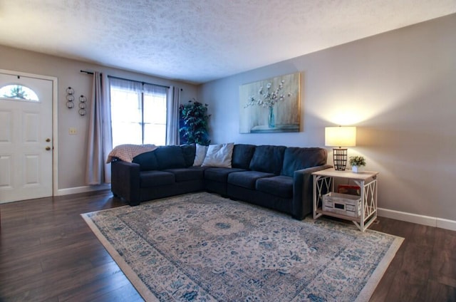 living room with dark wood-type flooring and a textured ceiling