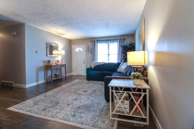 living room featuring dark wood-type flooring and a textured ceiling