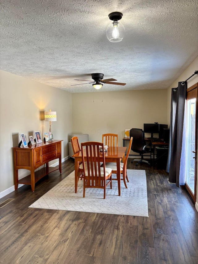 dining room featuring dark wood-type flooring, ceiling fan, and a textured ceiling